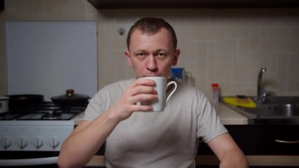 Hombre Sentado Casa Mesa Cocina Beber Café Una Taza Blanca — Vídeo de stock
