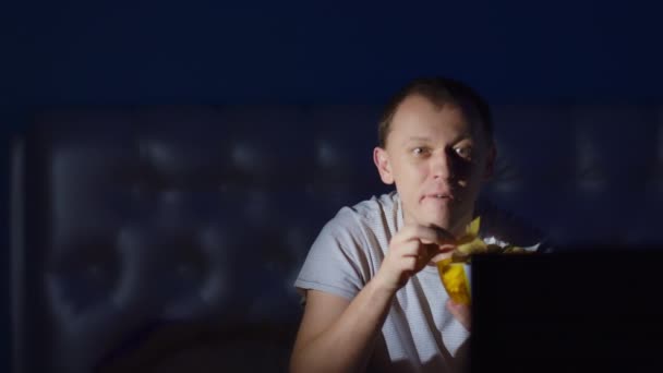 Sorpresa Cara Joven Viendo Televisión Comiendo Patatas Fritas Tarde Noche — Vídeo de stock