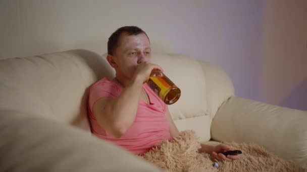 Mann Kosmetikmaske Trinkt Aus Einer Flasche Während Abends Auf Einem — Stockvideo