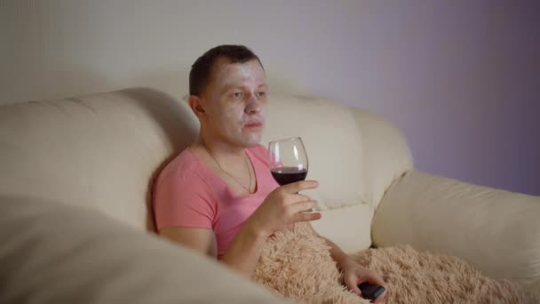 Hombre Sienta Sofá Por Noche Con Una Copa Vino Tinto — Vídeo de stock