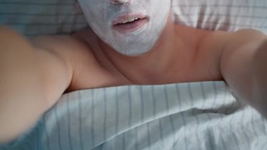 Yüzünde kozmetik maske olan genç bir adam elinde kamera, kamera hareketi.