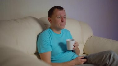 Genç adam akşamları bir fincan çayla kanepede oturur ve televizyon izlerdi.