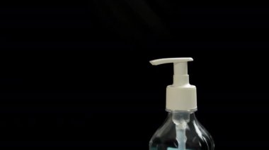 Kadın eli antiseptik kutusuna bastırır, yakın plan, koyu arkaplan