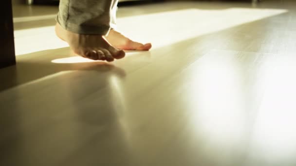 Male feet walking on light laminate, camera tracking — Stock Footage Male Feet Walking Light Laminate Camera Tracking Royalty Free Stock Footage