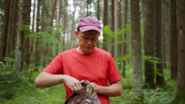 Erkek turist sırt çantasından su içmek için bir matara çıkarıyor.