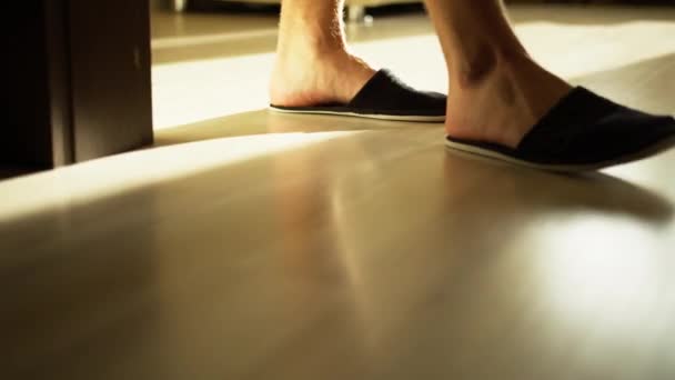 Man in cozy slippers walks on a light floor, camera tracking — Stock Footage Man Cozy Slippers Walks Light Floor Camera Tracking Royalty Free Stock Video