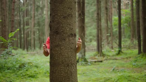 Hombre abrazando un tronco de árbol, unidad con la naturaleza — Vídeos de Stock