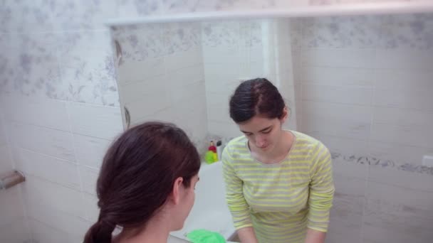 Ung flicka i badrummet tvättar händerna och torkar dem med en handduk, handhygien — Stockvideo