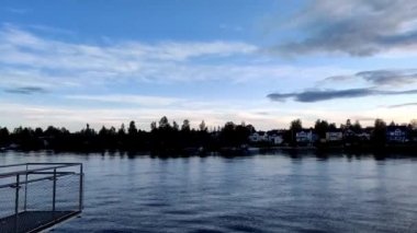 Günbatımı ile şehir ve güneş ışığı yansıtma üzerinden nehir bulutlarda ufku