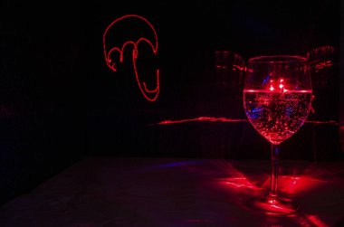 Şarap cam su ile bir şemsiye lazer ışık boyama 