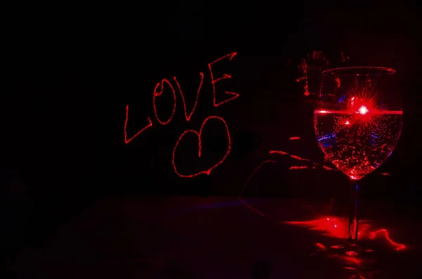 Laser drawn love sign for background with glassful of bubble dri