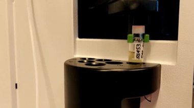 Robotik kol, kimyasal numunelerin analizi için bir makine içinde cam şişeleri hareketli