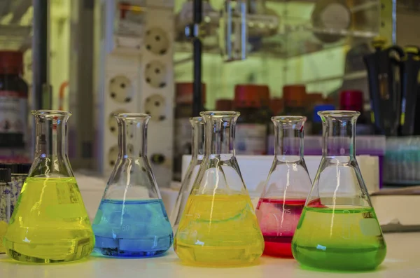 Solução colorida diferente em frasco cônico em um laboratório de química — Fotografia de Stock