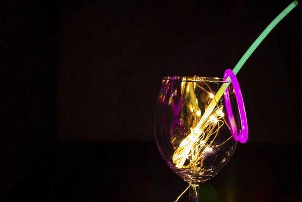 Μπλε και πράσινη λάμψη κολλήσει σε ένα ποτήρι κρασιού με το νέο έτος γιορτάζετε στο — Φωτογραφία Αρχείου