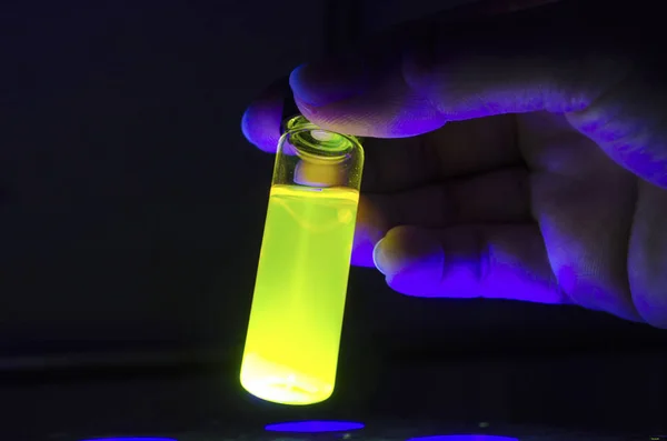 Researcher hand checking yellow close up photochemical reaction