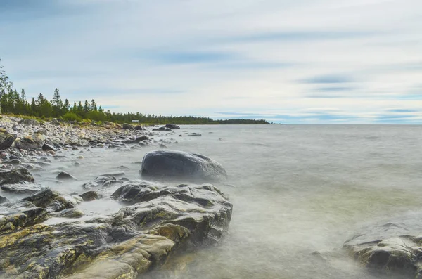 Wasserspritzer auf Steinen im Küstenbereich am Meer in einem sonnigen Norden — Stockfoto