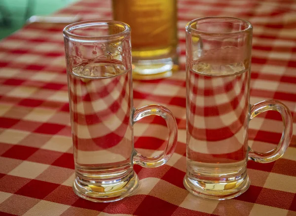 Vodka vaso de copa de alcohol mantenido en un patrón alrededor de un vaso de cerveza d — Foto de Stock