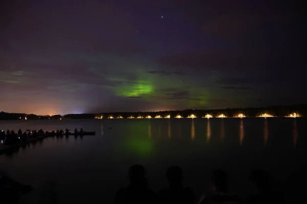 Groep van toeristen onder de sterrenhemel Aurora Borealis Noorderlicht wit — Stockfoto