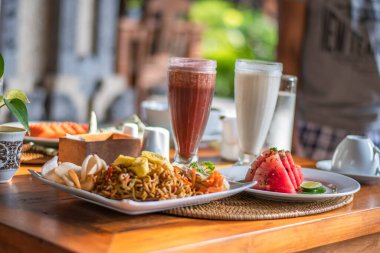 Endonezya 'da erişte, karpuz ve renkli smoothie ile servis edilen bir masada bale kahvaltısı.