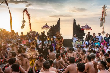 Uluwatu, Bali, Endonezya - 22 Aralık 2019 Hint mitolojisi hikayeli bir grup insanın geleneksel Kecak dansı ile altın saat günbatımı