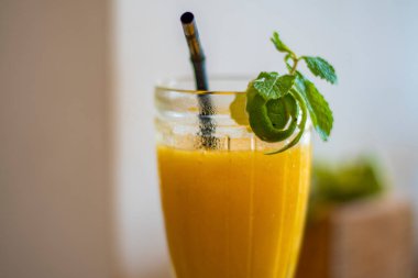 Limon kabuğu ve Endonezya 'da yapraklarla süslenmiş bir restoranda soğuk renkli taze portakal suyu.