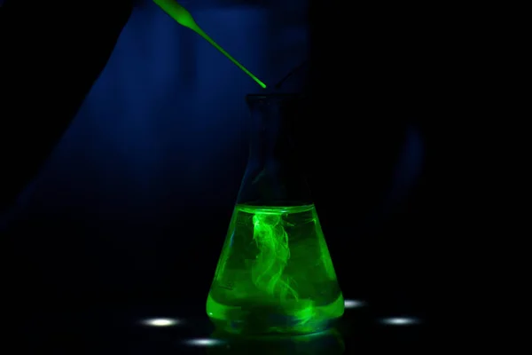医薬品開発のためのダーク生化学研究所の緑の蛍光化合物を扱う科学者 — ストック写真