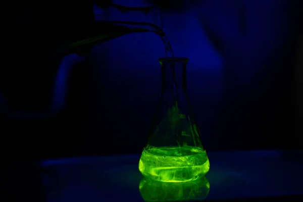 Egy Kutató Aki Zöld Fluoreszkáló Oldattal Dolgozik Egy Üveg Erlenmeyer — Stock Fotó