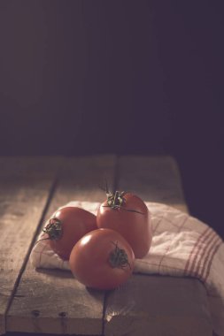 ahşap masa üzerinde üç kırmızı domates