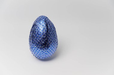 Ev yapımı Paskalya yortusu yumurta parlak mavi folyo sarılı. Beyaz bacground izole.