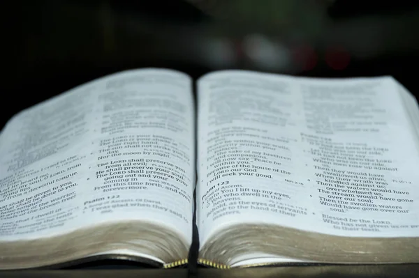 Primer plano de la Santa Biblia abierta en el Salmo 121. Fondo borroso . — Foto de Stock