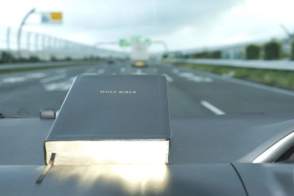 Sainte Bible avec une lueur dorée. Fond flou avec autoroute . — Photo