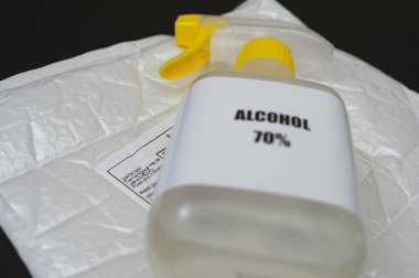 % 70 alkol spreyi baloncuk ambalajlı zarfın üstünde Post etiketi var. Siyah arka planda izole edilmiş. Seçici odak.