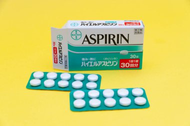 Fuji Şehri, Shizuoka Eyaleti, Japonya - 26 Mart 2020: BAYER tarafından ASPIRIN - Japonya 'da ağrı, ateş ve iltihaplanma için popüler ve geleneksel tedavi. Sarı arkaplanda izole edilmiş.