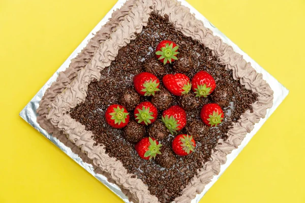 自制的巧克力蛋糕 上面撒满了巧克力和新鲜草莓 在巴西被称为 Bolo Brigadeiro 被黄色背景隔离 顶部视图 — 图库照片