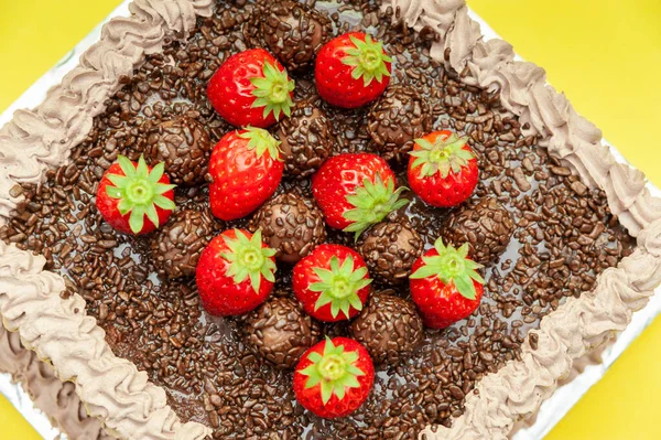 自制的巧克力蛋糕 上面撒满了巧克力和新鲜草莓 在巴西被称为 Bolo Brigadeiro 被黄色背景隔离 顶部视图 横向射击 — 图库照片
