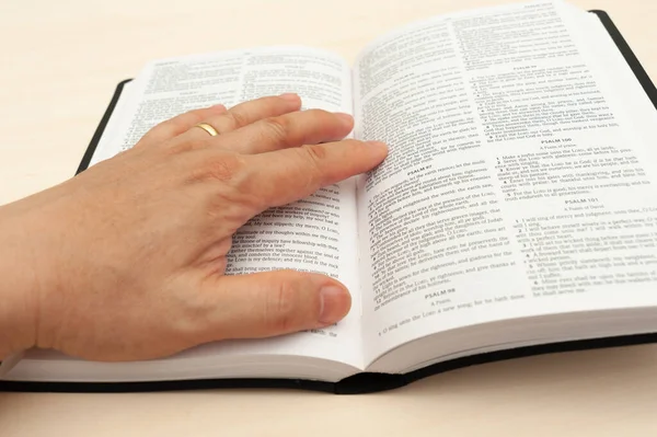 Hand on the Holy Bible in close-up. Studying and reading the Word of God. Top view.