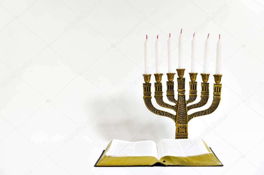 Menorah and open bible with 7 unlit candles isolated on white background. Copy space. Horizontal shot.