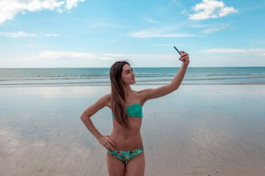 bir kadın bir mayo içinde bir selfie denizde yapar