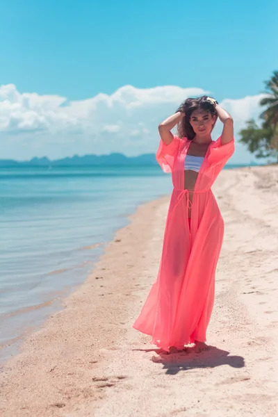 Portrait de jeune femme portant un sarong rose et un bikini sur la plage tropicale — Photo