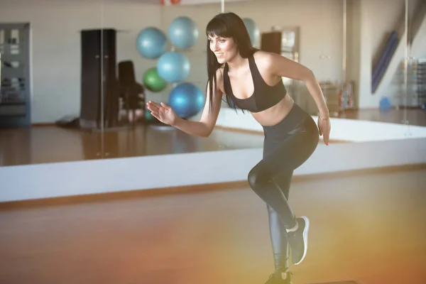 fitness girl trainer in gym in running position