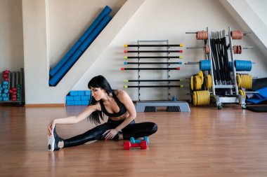 Uygun kadının geri kasları germe egzersizleri yapması ve bacaklar bir eğitim önce ısınmak spor salonu konsept fitness, spor, yaşam tarzı.