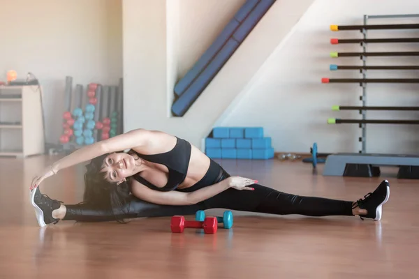 Mooie jonge sportieve vrouw stretching op Gym. — Stockfoto