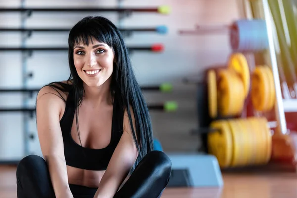 Schattige glimlachende atletische fitness meisje poseren in de sportschool. — Stockfoto