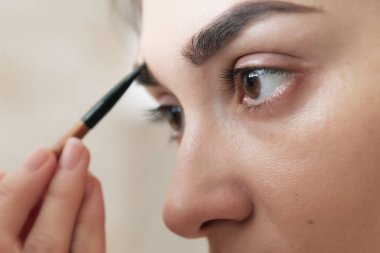 Kaş farı uygulaması, kaş modelleme makyajı, yakın çekim. Moda makyaj, güzellik konsepti ile kadın model yüz
