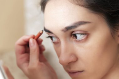 Kaş farı uygulaması, kaş modelleme makyajı, yakın çekim. Moda makyaj, güzellik konsepti ile kadın model yüz