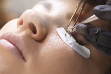 Kirpik uzatma prosedürü. Uzun kirpikli kadın gözü.