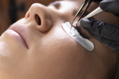 Kirpik uzatma prosedürü. Uzun kirpikli kadın gözü.