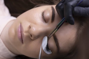 Kirpik uzatma prosedürü. Uzun kirpikli kadın gözü.