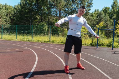 bir ip ile stadyumda atletik adam. Sağlıklı yaşam tarzı. Sokakta spor aktiviteleri