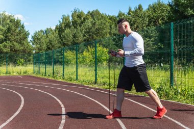 bir ip ile stadyumda atletik adam. Sağlıklı yaşam tarzı. Sokakta spor aktiviteleri